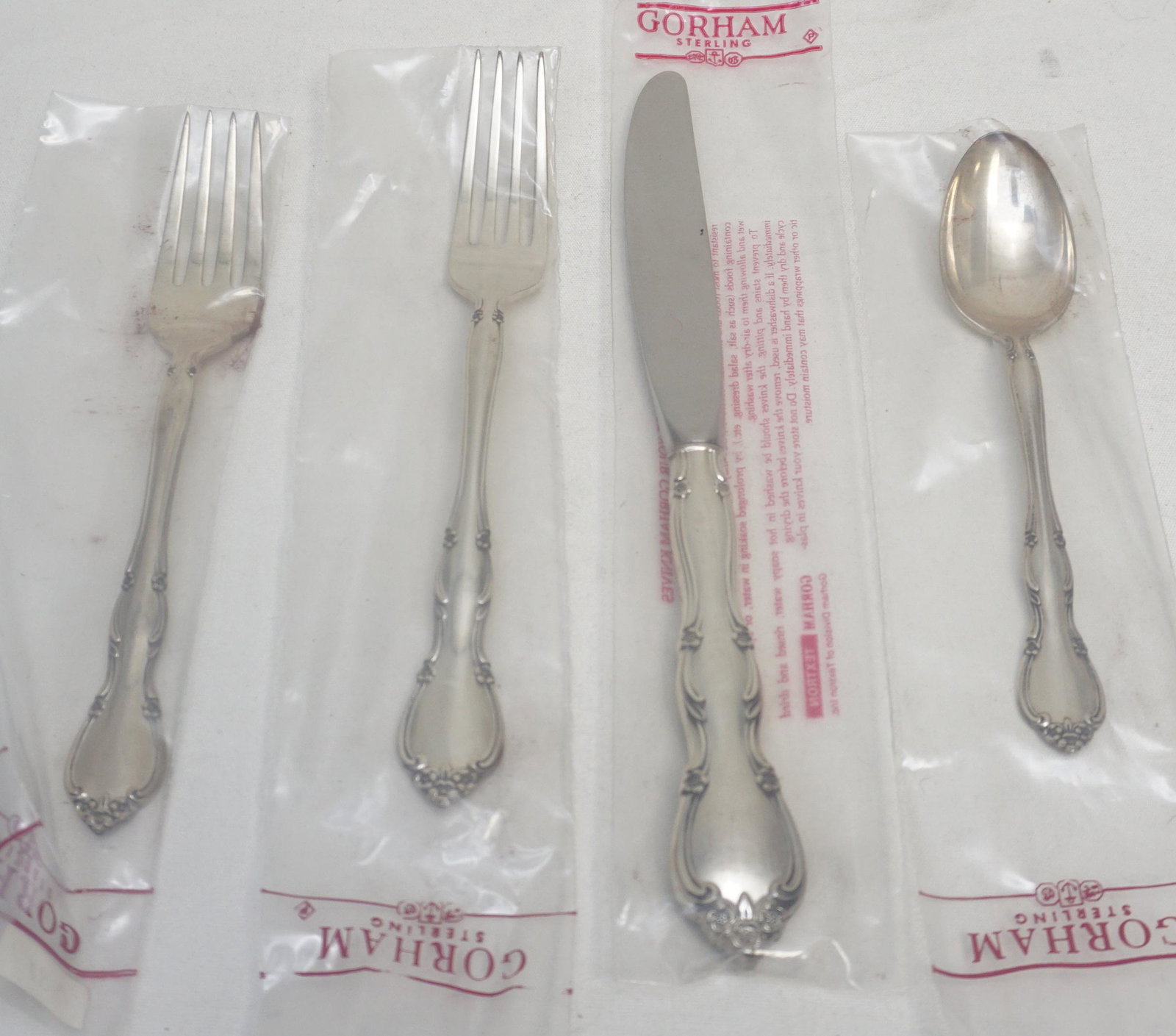 4 pc GORHAM STERLING ROSE TIARA PLACE SETTING: Gorham Sterling Silver Rose Tiara 4 Piece Place Setting, New in wrappers. Diner Fork, Salad Fork, Teaspoon and Modern Hollw Kinfe. PROVENANCE: A Charleston SC Private Estate