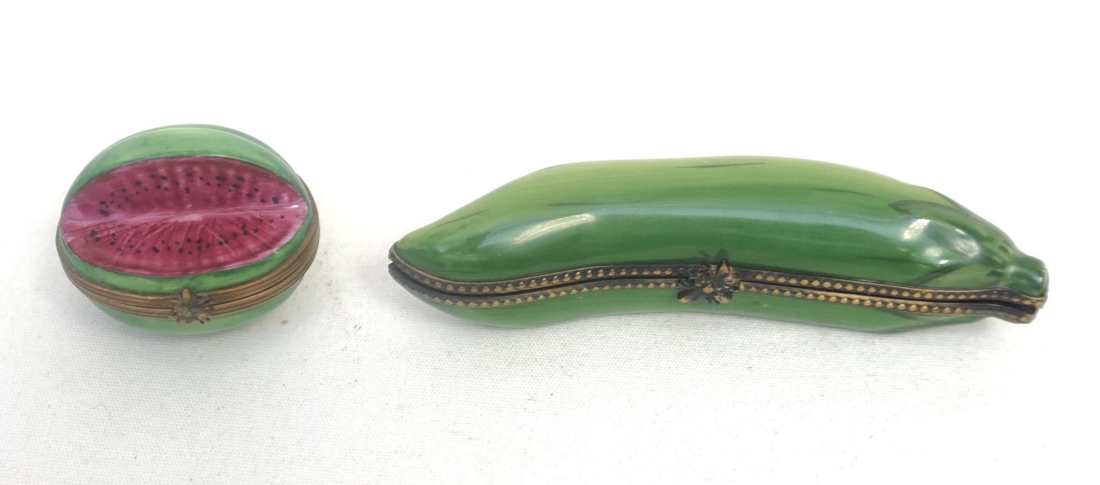 2 PC LIMOGES PEAS IN A POD & WATERMELON BOXES: 1 - 5 Green Peas in a Pea Pod Peint Main French Limoges Signed 4 1/2" long. 2- Watermelon Peint Main French Limoges Signed Trinket Box 1 3/4". Both in good condition. Weight 6 oz. PROVENANCE: A Privat