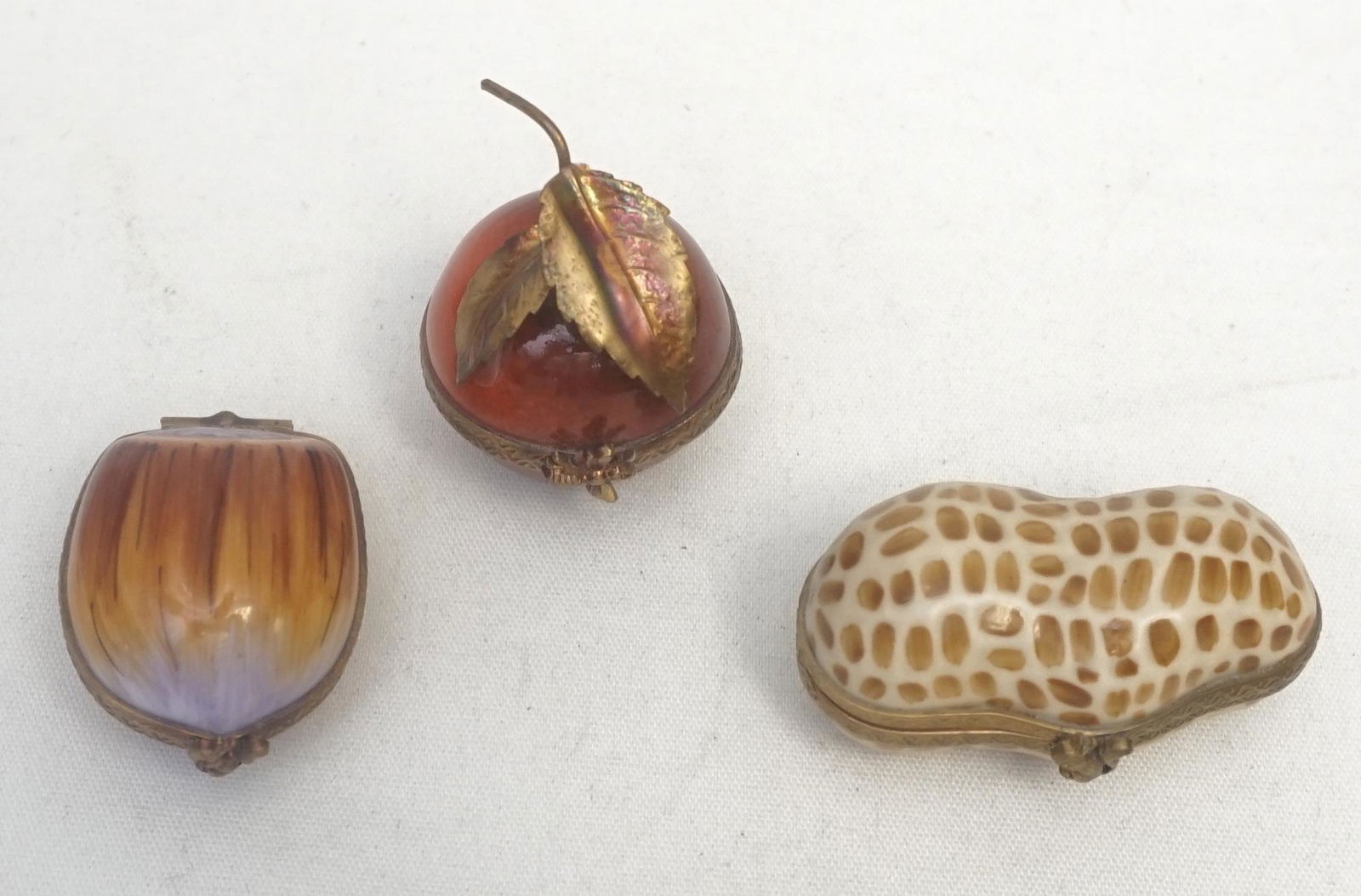 3 PC LIMOGES PEANUT, APPLE, NUT BOXES: 1 - Limoges Signed Peint Main Peanut Box with 2 Peanuts inside and squirrel clasp 2". 2- Limoges Dubarry Signed Peint Main Apple Box with bee clasp 1 3/4". 3- Limoges Signed Peint MainAcorn Box with n