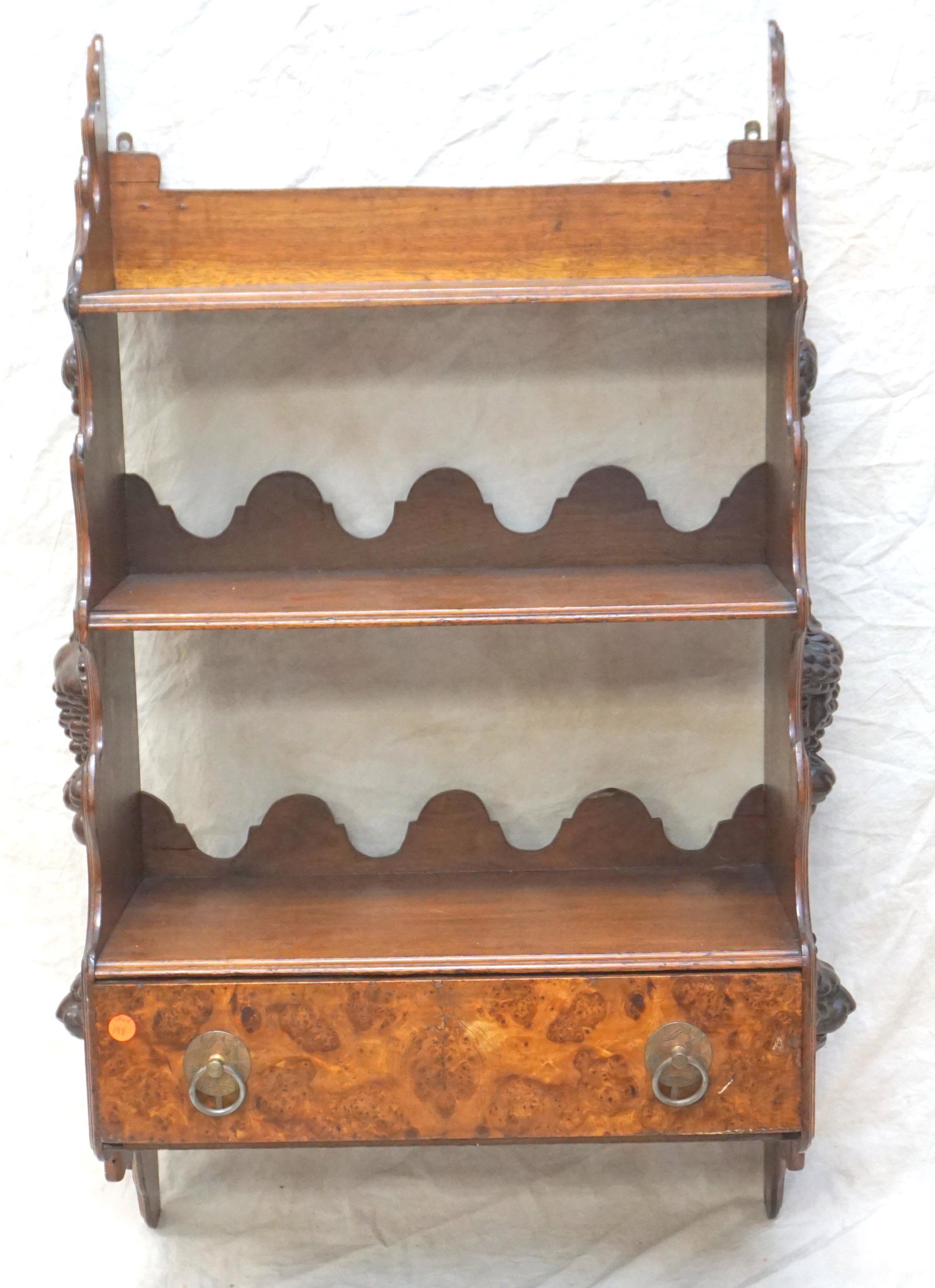 ANTIQUE WALL SHELF WITH CARVINGS: Early 20th c. Walnut Wall Shelf, Burl Front Drawer and 3 Shelves. Applied Carvings each side. Measures 21"x12"x41". NO IN HOUSE SHIPPING. PROVENANCE: A Private Charleston SC Estate.***Pickup only or S