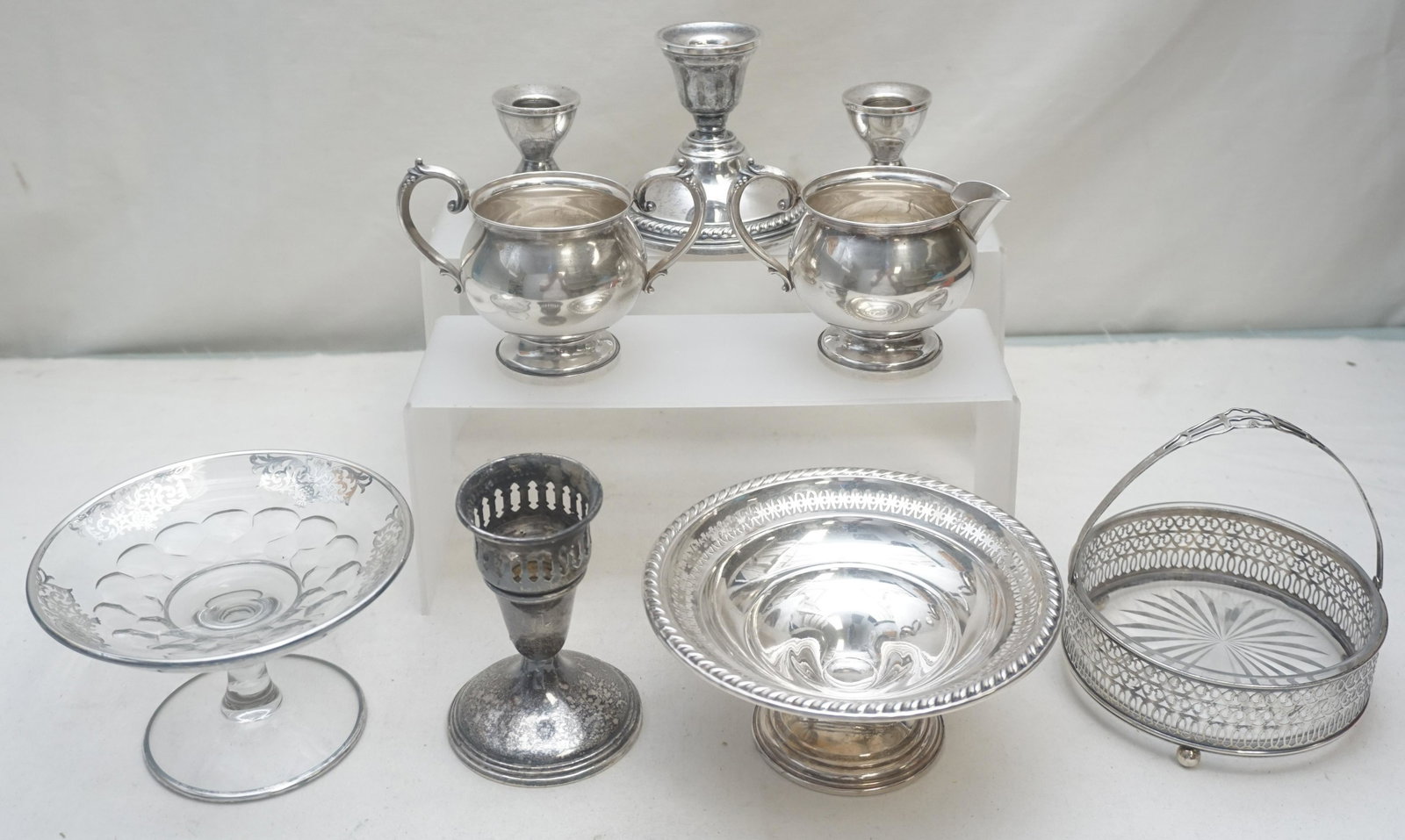 9 PC STERLING COMPOTE - CANDLESTICKS - CREAM & SUGAR: All are weighted sterling silver or glass. 1- La Pierre Compote 6" wide. 2- Crystal Candy Dish in Silver Basket 4 3/4" wide. 3- Pair short Candlesticks 2 1/4". 4- 1 Empire Candlestick, tarnished 4". 5