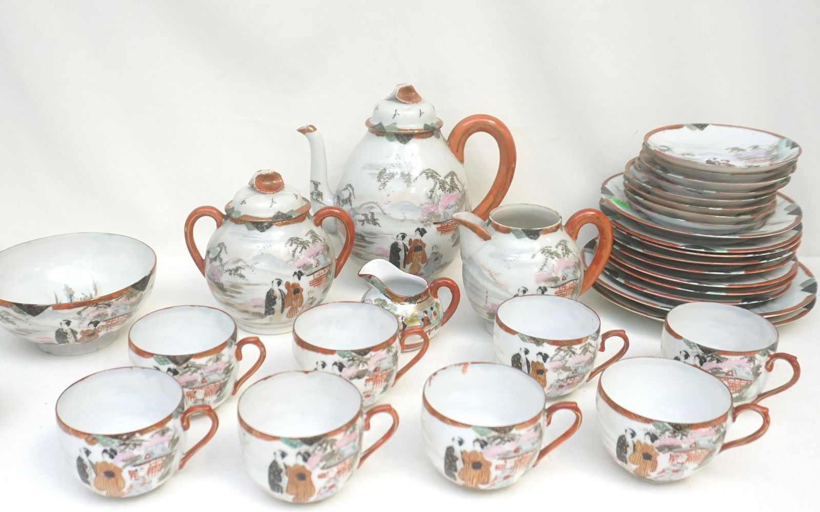 31 PIECE JAPANESE GEISHA WARE TEA SERVICE: Vintage early 20th c. Japanese Tea Service. Geisha. Includes Teapot 8 1/4", Cream and Sugar 6". Bowl 6". 8 Cups 2 1/2". 8 Saucers 5 1/4". 8 Dessert Plates 7". 2 Plates 8 1/4". 1 Tiny Creamer 2 1/2". W