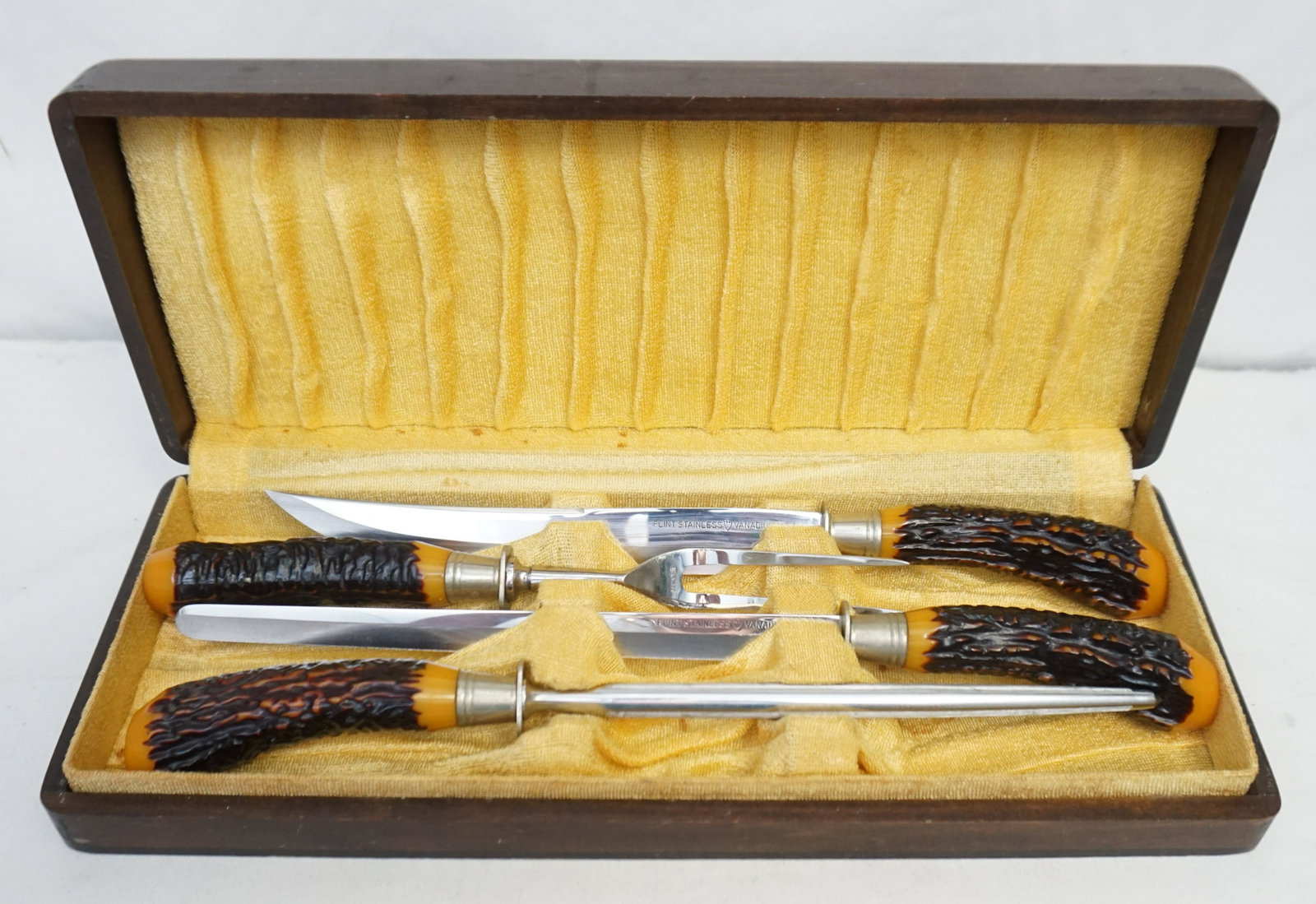 4 pc VINTAGE FLINT STAINLESS BAKELITE STAG HORN CARVING: Four Piece Vintage Flint Stainless Vanadium USA Faux Stag Horn Bakelite Handle Carving Set. In the original wood Box. Very good condition. Box measures 16"x6 1/2"x2 1/2". Weight 3 pds 13 oz. PROVENANC