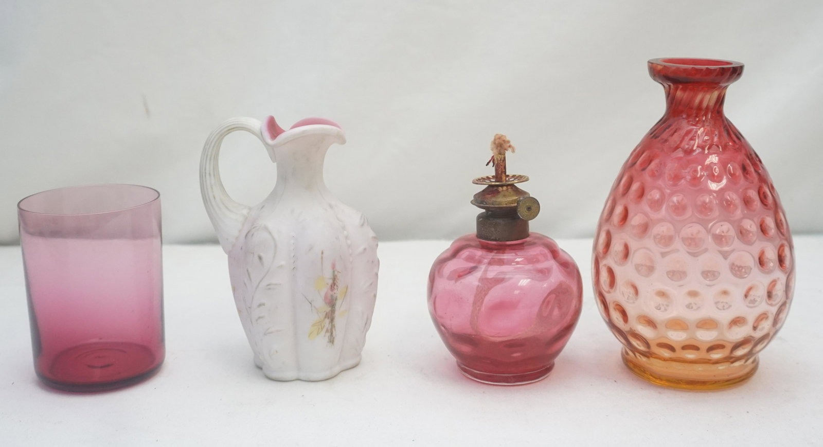 4 pc VTG CRANBERRY & CASED GLASS: 1- Antique Miniature Acorn Cranberry Dot Optic Oil Lamp 4 3/4". 2- Antique Amberina Dot Optic Vase 6 1/2". 3- Antique White Cased Cranberry Jug, Hand Painted 5 1/2". 4- Antique Blown Cranberry Glass T