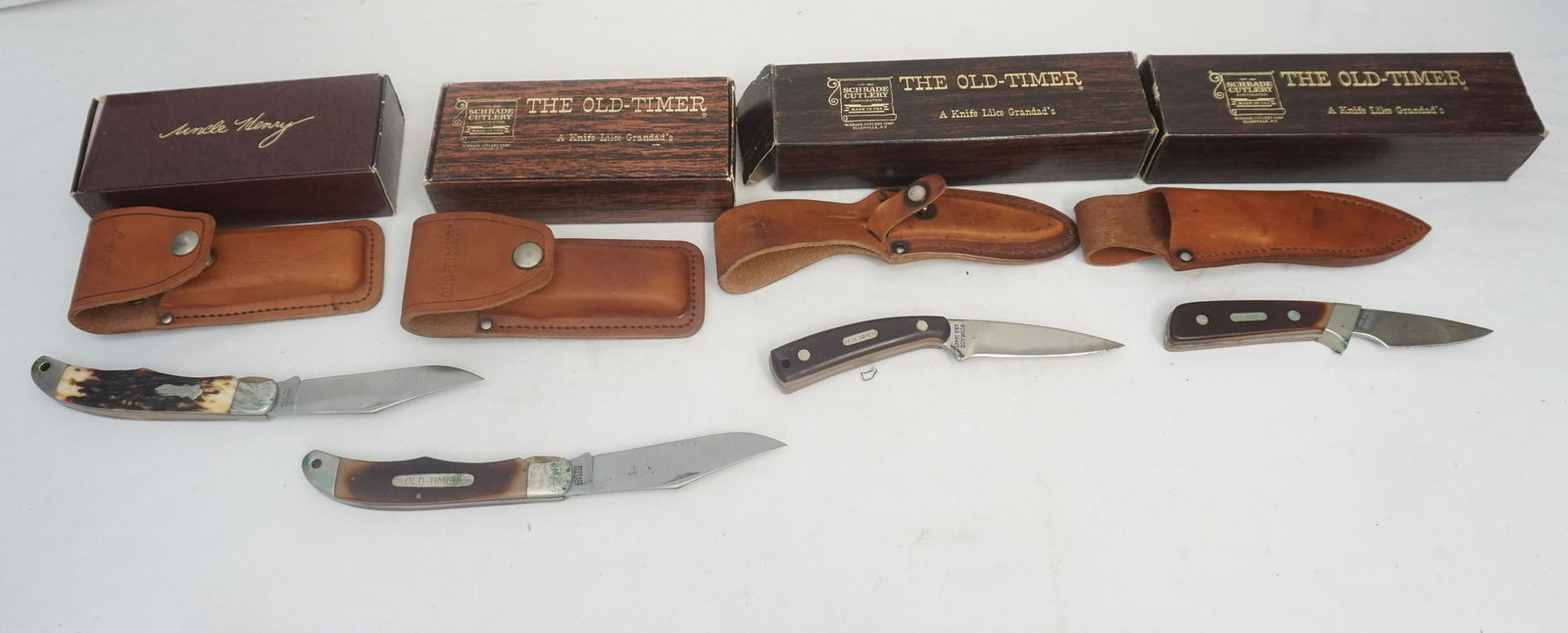 4 VINTAGE SCHRADE KNIVES IN BOXES: All are by Schrade. All are Vintage 1970s. 1- The Old Timer Drop Point Sharpfinger 1540T with Leather Sheath Still in box. 2- Uncle Henry 127UH Lock Blade with Leather Sheath in box. 3- Old Timer 1560