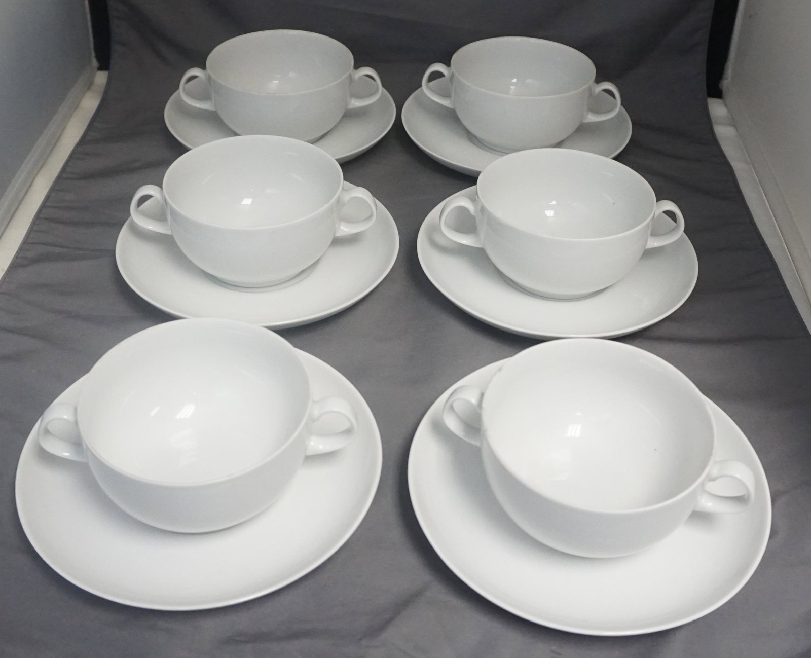 12 PC ARZBERG WHITE CREAM SOUPS & SAUCERS: 12 pc Vintage German Arzberg White (Form 2000) Cream Soup & Saucers. 6 Saucers 6 3/4". 6 Cups 5 1/2"x4"x2 1/4". Weight on all 5 pds. PROVENANCE: A Private Charleston SC Estate.