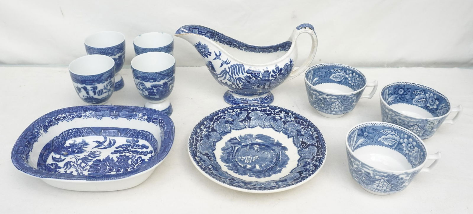 10 PC ENGLISH & JAPANESE BLUE & WHITE: 1- English Staffordshire Willow Ware Gravy 8 1/2" long. 2- Masons England Plate / Saucer 7 1/4". 3- 3 English Woods Teacups 3 3/4"x2 1/4". 4- Four Maruta Japan Willow Ware Egg / Custard Cups. 3 3/4".