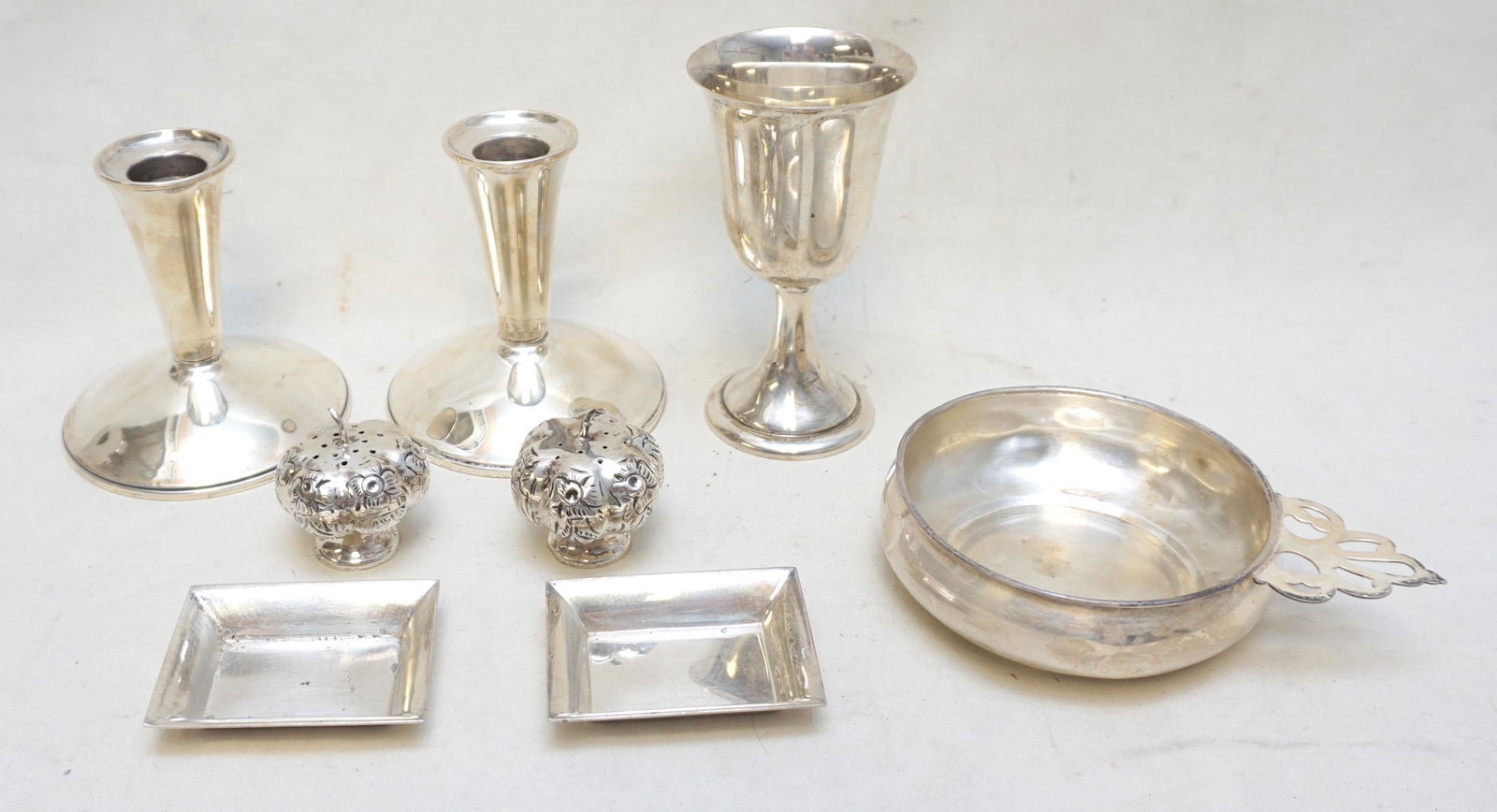 8 pc STERLING SILVER CANDLESTICKS +: 1- Sterling Wine 4 3/4". 2- Sterling Porringer 5 1/2" ding. 3- Pair (2) Sterling Floral Form Salts each 2". 4- Pair (2) Stieff Sterking Nut Dishes 2 5/8". 5- Pair (2) Weighted Sterling Candlesticks 4"