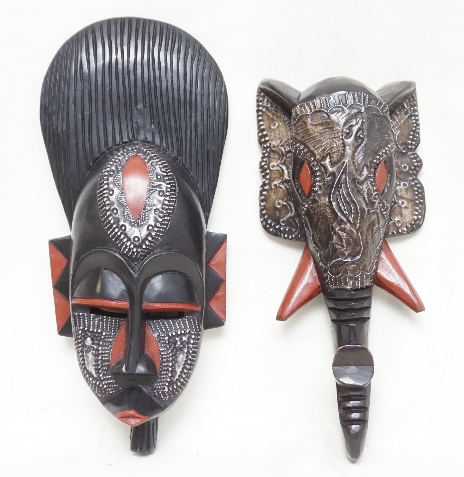 PAIR OF GHANA HAND CARVED MASKS: Pair of 20th c Hand Carved and Painted Masks From Ghana with Hand Hammered Metal Accents. Elephant 14 1/2". Tribal Mask 16 1/2". Weight combined 3 pds 11 oz. PROVENANCE: A Private Charleston SC Estate