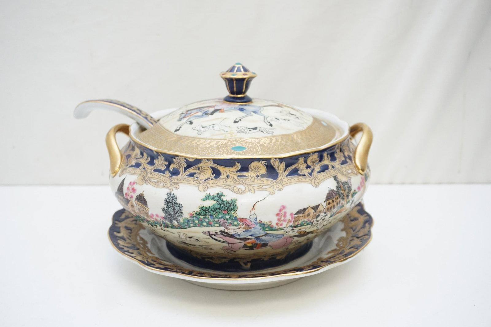 PORCELAIN HUNT SCENE TUREEN W LADLE: Vintage Hunt Scene Tureen with Tray and Ladle. The tureen and cover decorated with hunt scenes featuring a horseman in European style clothing. Mark for Da Qing Qianlong Nian Zhi - "Great Qing Dynasty