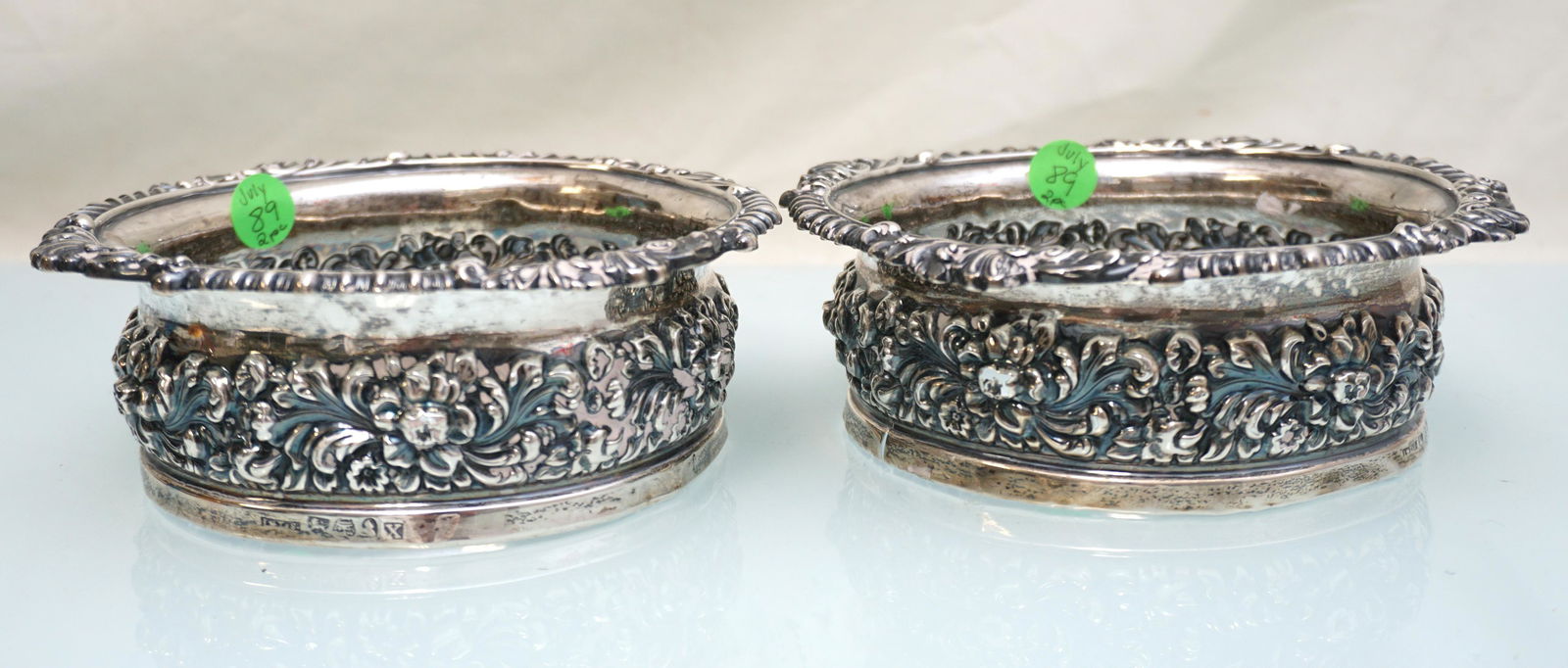 MATCHED PAIR GEORGIAN STERLING REPOUSSE WINE COASTERS: Matched Pair of Antique Georgian Sterling Silver 19th C Repousse Wine Coasters missing the wood insert on both. Each 6 3/4"x2 1/4". Approximate Silver Weight 354 grams. PROVENANCE: A Charleston SC Pri