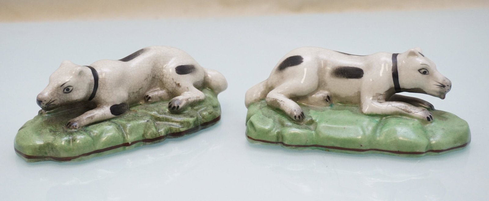 ENGLISH STAFFORDSHIRE STYLE RECLINING HOUNDS: Vintage English Staffordshire StyleReclining Spaniels / Hounds. Each 5" long. Weight combined 1 pd. PROVENANCE: A Charleston SC Private Estate.