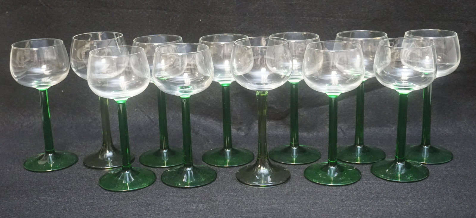 12 CRISTAL D'ARQUES-DURAND EMERALD STEM WINE GLASSES: 12 Cristal D'Arques Durand Rhine Wine Emerald Stem Made in France Glasses with Green Gingham Case. Each 6 1/2". Case 12"x16"x10". Weight 3 pds 5 oz. PROVENANCE: 25 East Battery, Charleston SC. The Cha