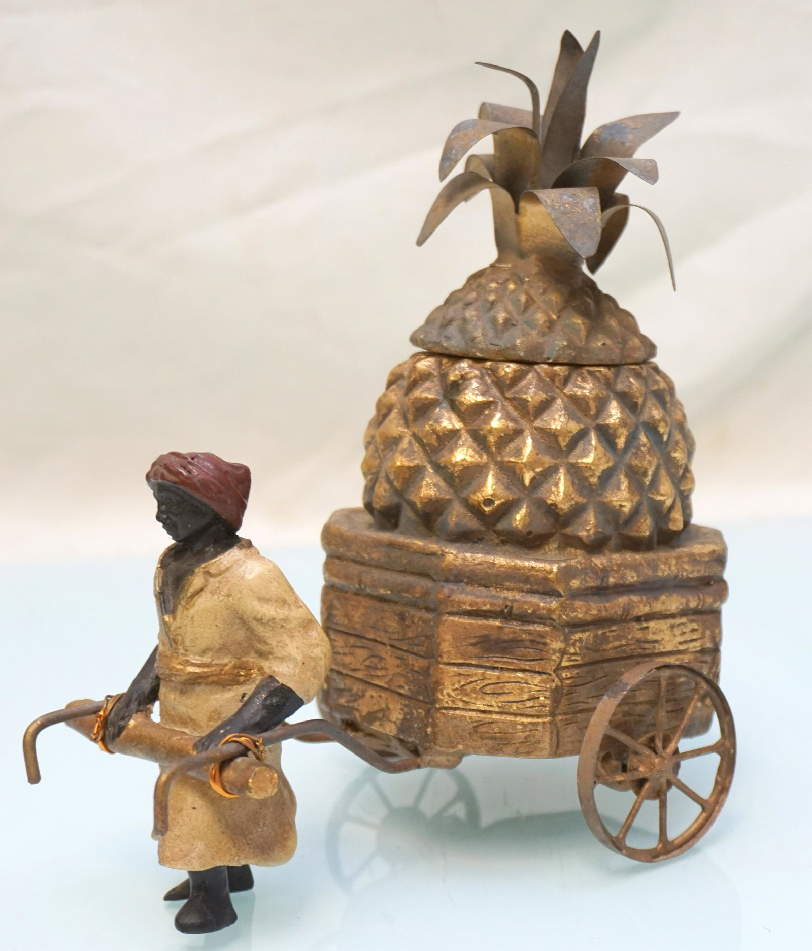VINTAGE BLACKAMOOR WITH PINEAPPLE CART: Vintage 20th c. Composite Blackamoor pulling Pineapple Cart Box. Measures 6 1/2"x4 1/4"x7". Weight 1 pd 2 oz. PROVENANCE: A Charleston SC Private Estate.