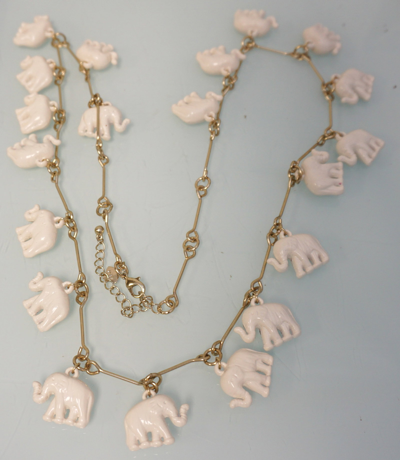 TORI SPELLING ELEPHANTS CHARM NECKLACE: Tori Spelling White Elephant Charms Necklace. Trunks raised. 36" opened. PROVENANCE: A Private Charleston SC Estate