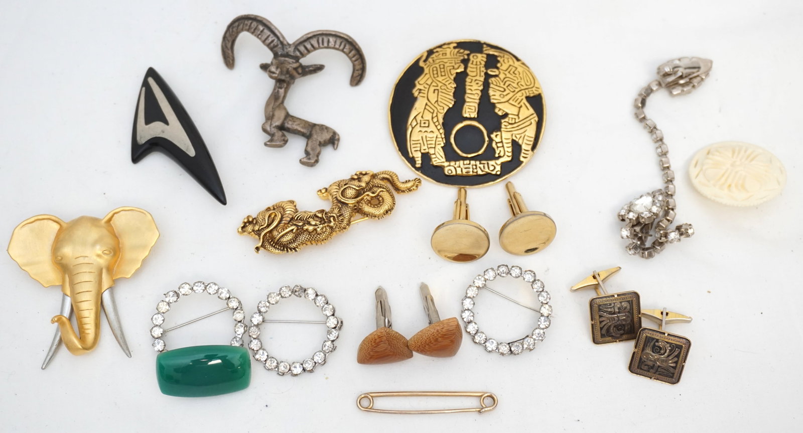 14 pc VINTAGE COSTUME JEWELRY INCL CUFFLINKS: All are vintage. 3 Pairs of Cufflinks. Large Mayan Brooch Brass 2.5". 3 Rhinestone Brooches and 1 Rhinestone Sweater Clip. Carved Bone Brooch. Danish Silver Inlay Modernist Brooch 2.75". Mountain Goat