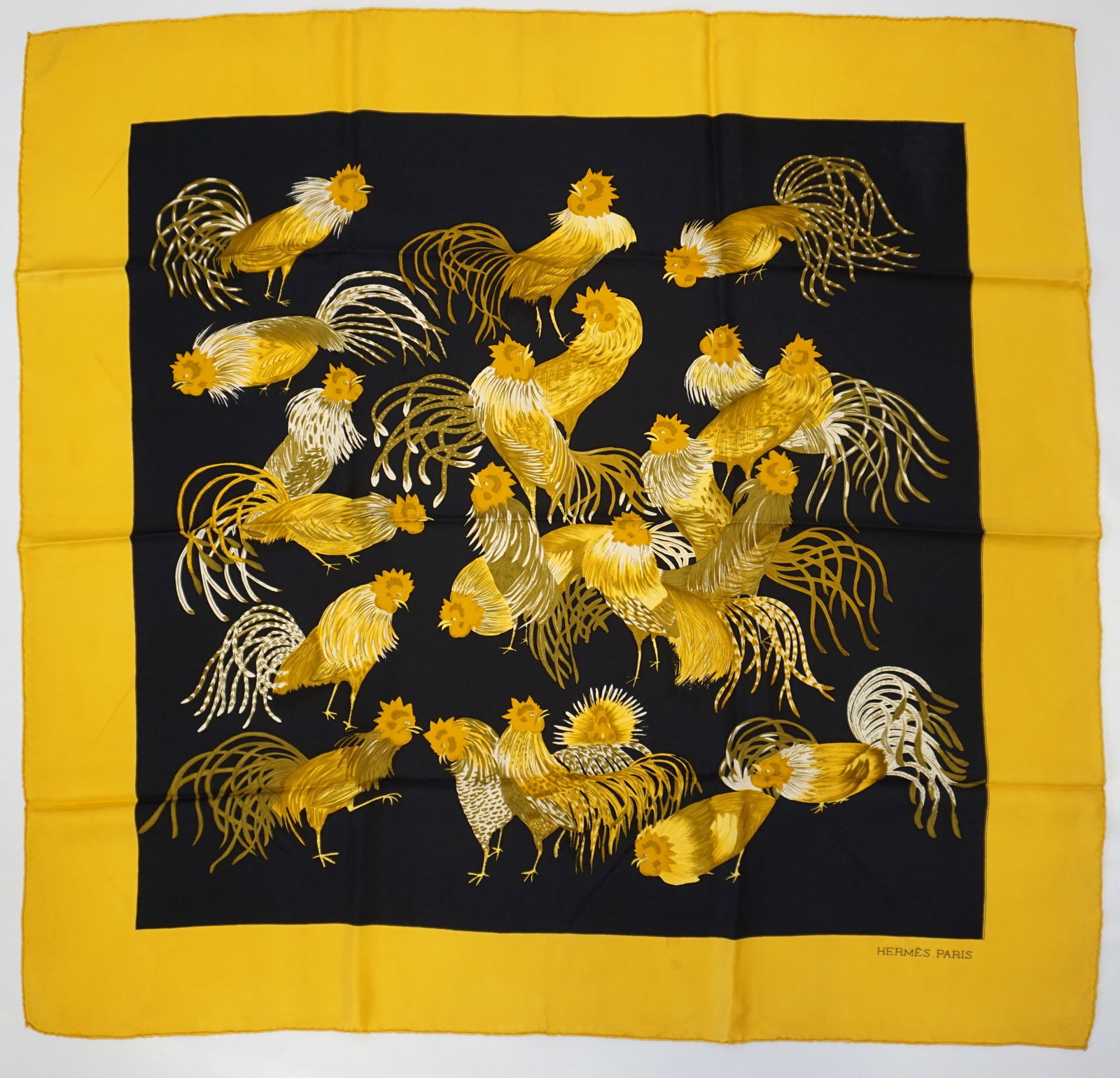 HERMES PARIS "LES COQS" SILK SCARF: HERMES PARIS silk "les Coqs" scarf. The scarf features drawings of roosters in gold and yellow on a black background, accompanied by a yellow border. Drawn by Madame La Torre, first edition in 1964, n