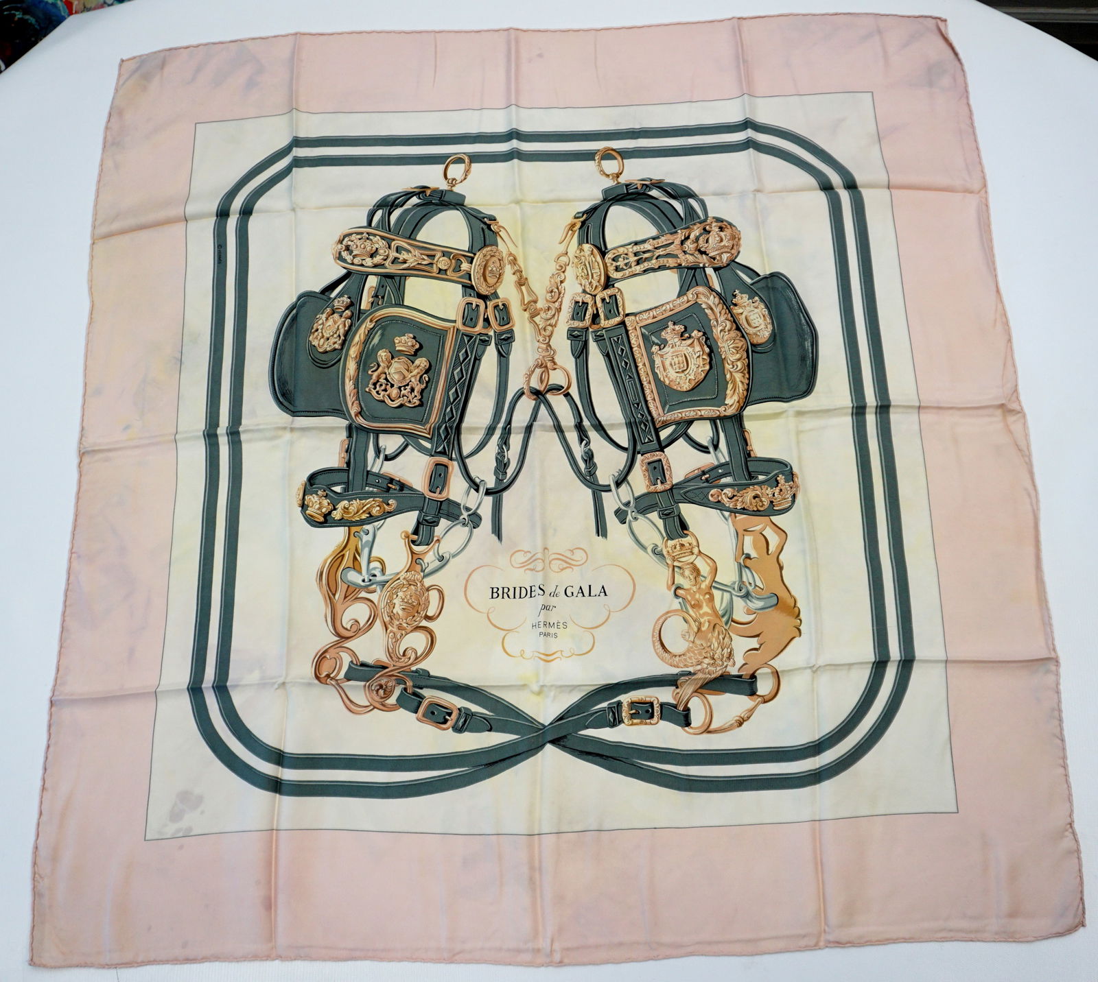 HERMES PARIS "BRIDES DE GALA" SILK SCARF: HERMES PARIS silk “Brides de Gala” scarf. The scarf features a symmetrical arrangement of intricately detailed bridles, bits, and harnesses, woven together with minimalistic colors, here i