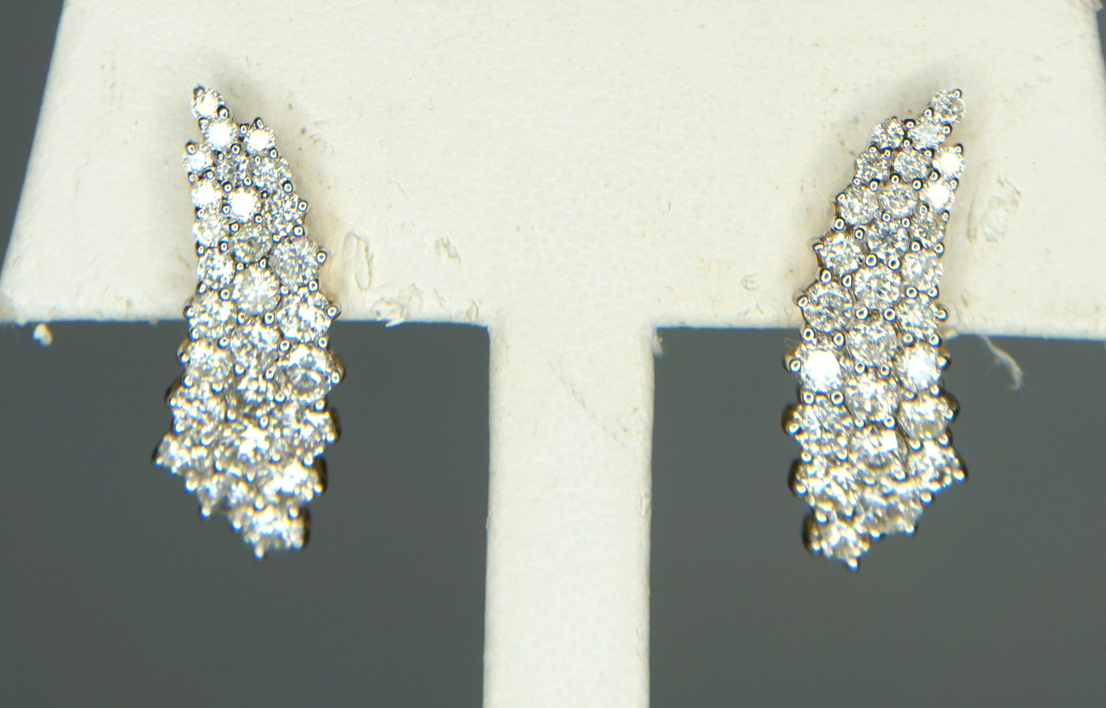 2.97CTS/TW 14KT GOLD DIAMOND EARRINGS: Pair of 14kt gold 2.97cts/tw cascading graduated diamond earrings. The earrings measure approx. 24.55 x 9.55mm and feature three rows of shared prong set round brilliant cut diamonds which graduate wi