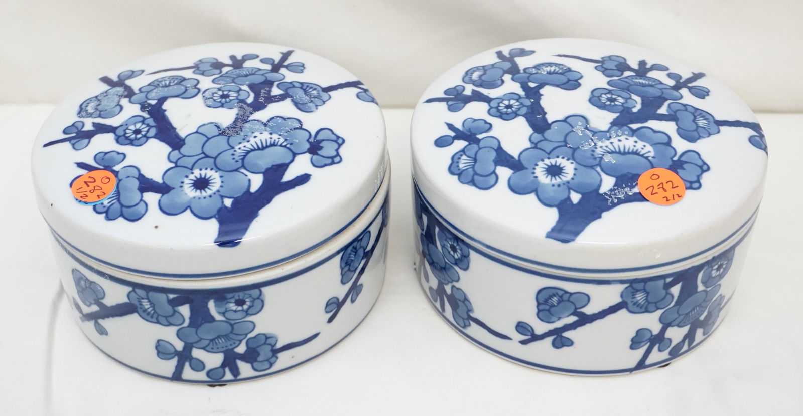2PC BLUE & WHITE DECORATIVE BOXES: Pair of two contemporary, vibrant, ceramic round blue and white decorative boxes. The pieces are designed with a blue floral motif set on a white background. Each measures approx. 6.50" across x 3.5"