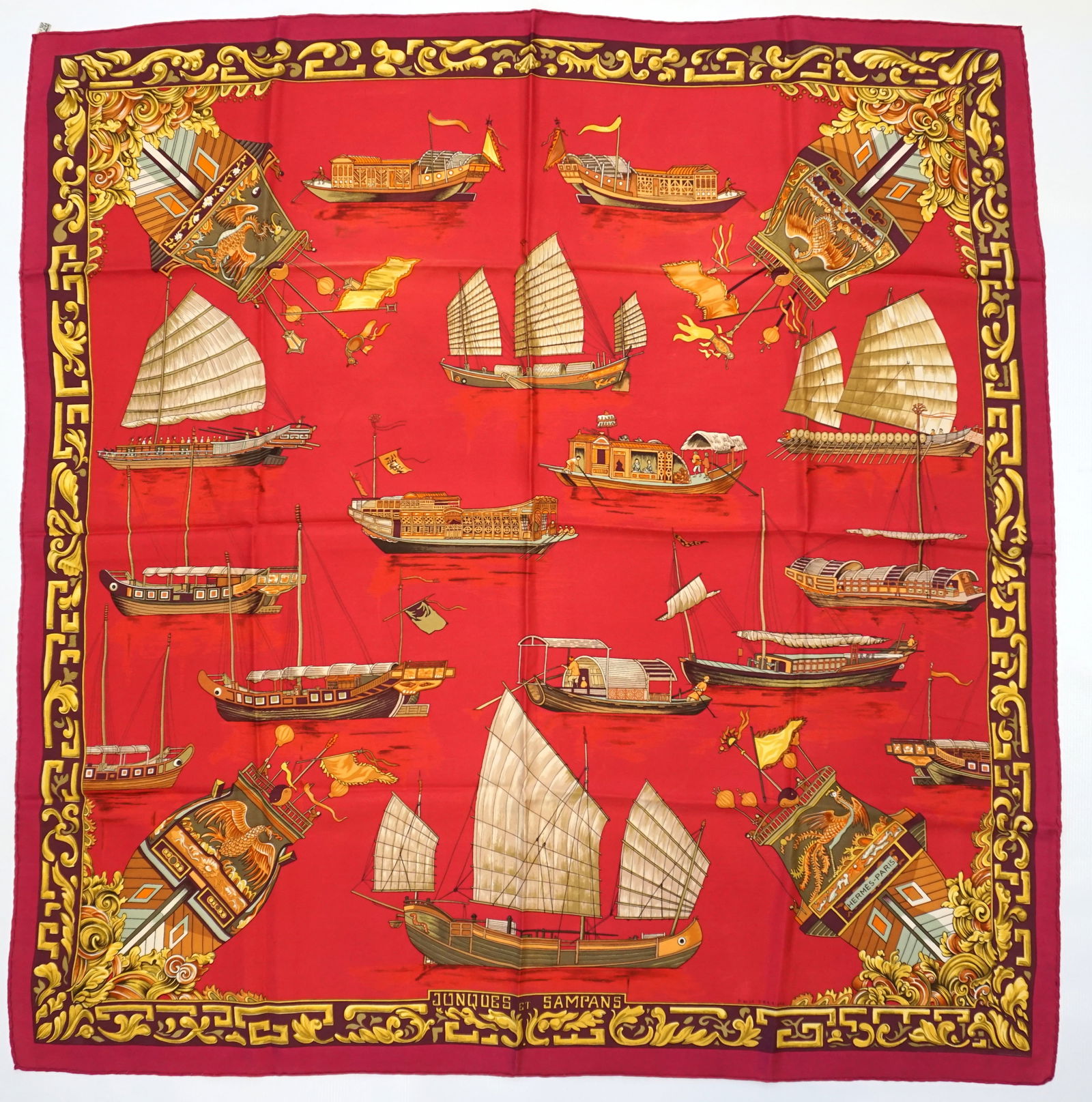 HERMES PARIS "JONQUES ET SAMPANS" SILK SCARF: HERMES PARIS silk "Jonques et Sampans" scarf. The scarf features drawings of traditional Junks and Sampans from various Asian countries in shades of gold with beige details. The scarf setting is a vib