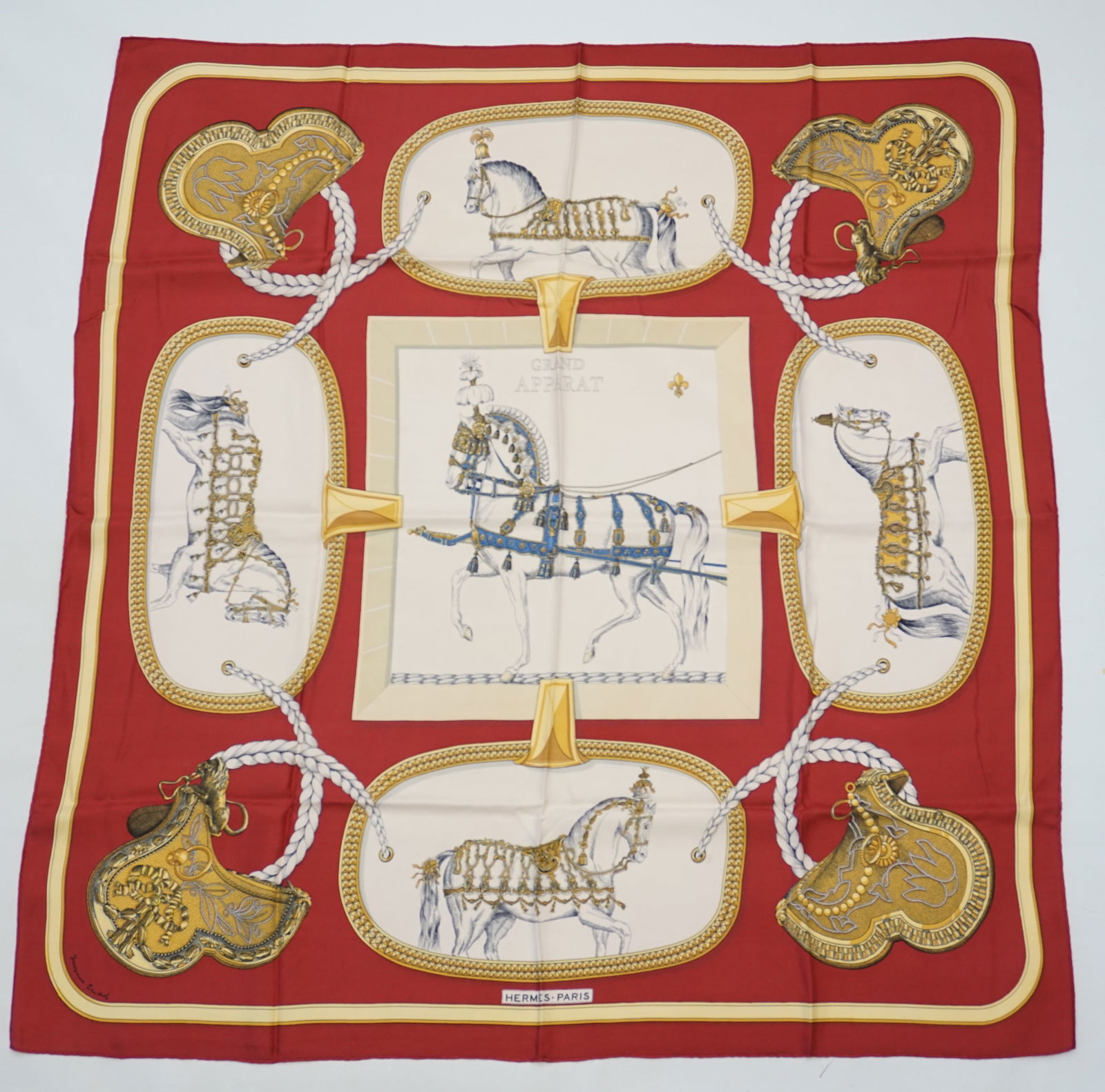 HERMES PARIS "GRAND APPARAT" SILK SCARF: HERMES PARIS silk "Grand apparat" scarf. This scarf features various horses heavily ornamented with golden bronze equestrian equipment, the central one in a bright blue embroidery, the four other symm