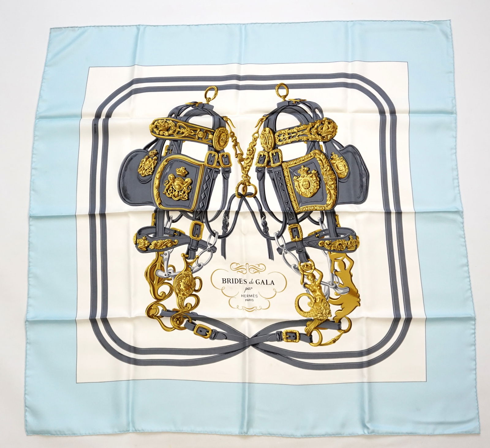 HERMES PARIS "BRIDES DE GALA" SILK SCARF: HERMES PARIS silk “Brides de Gala” scarf. The scarf features a symmetrical arrangement of intricately detailed bridles, bits, and harnesses, woven together with minimalistic colors, here in wh