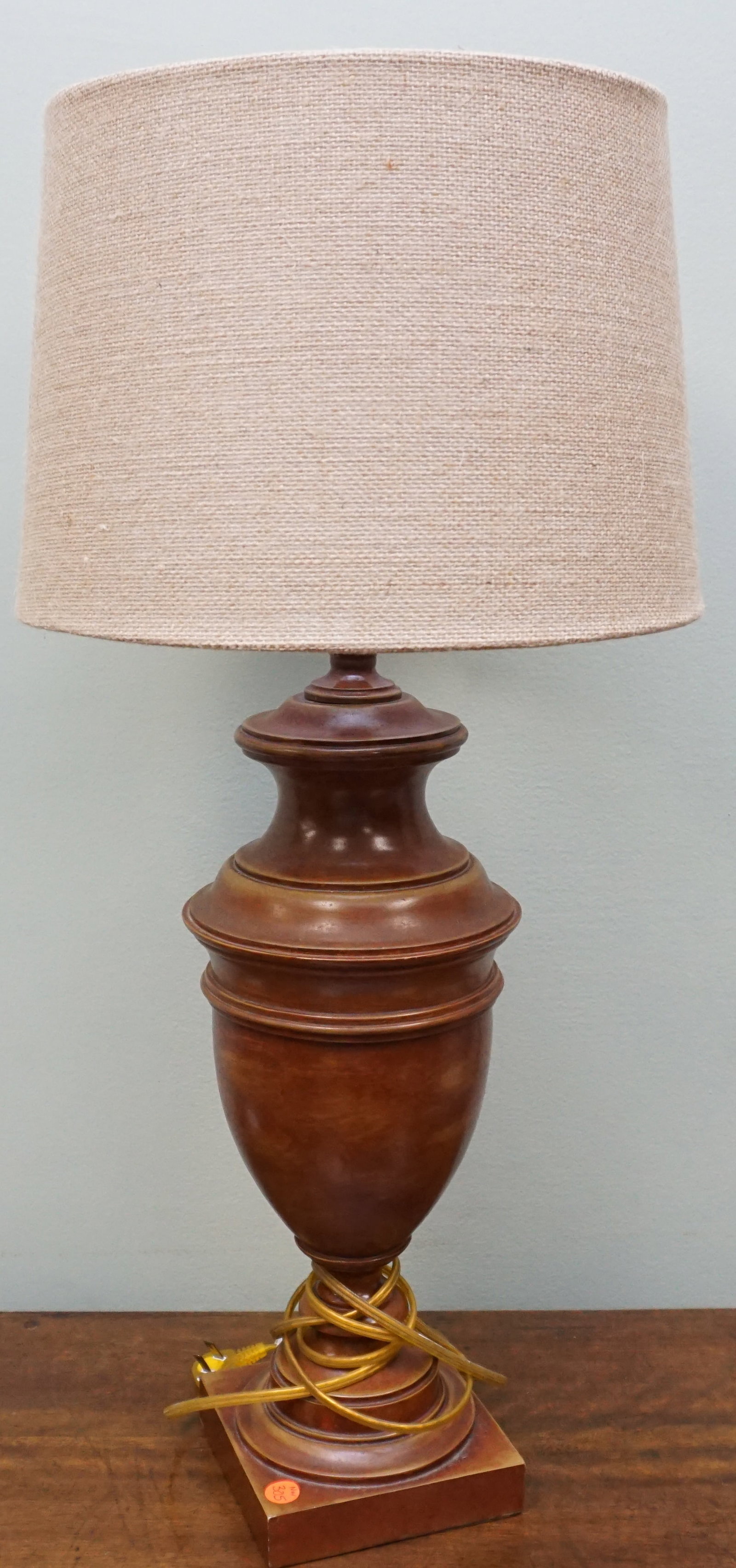 CONTEMPORARY WOOD LAMP: The urn style lighter wood lamp is banded with many tiers and a woven round shade. The lamp with shade measures approx. 30". weight 7 lbs. NO IN HOUSE SHIPPINT
