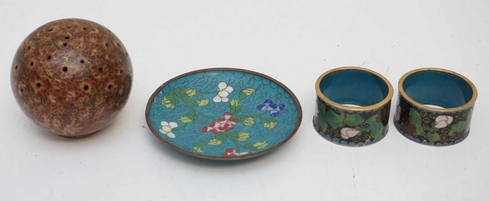 4PC CLOISONNE: Group of 4 cloisonne pieces including: 1- 2pc napkin rings; 2- red pierced shpere; 3- round ring dish (some loss to back). Total weight 14oz.
