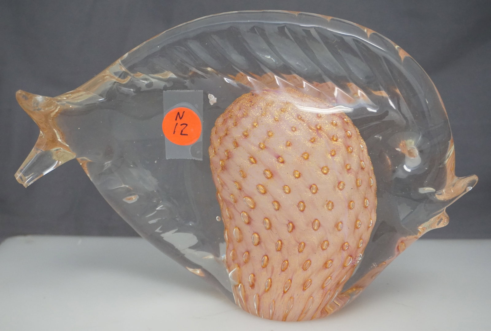 MURANO GLASS PUFFER FISH SCULPTURE: Vintage Murano hand blown glass pufferfish sculpture. The fish has a center pink & gold balloon of color and ribbed top and base for fins. Measures 8.25x6" (h), weighs 4lbs. Small chip to tail.