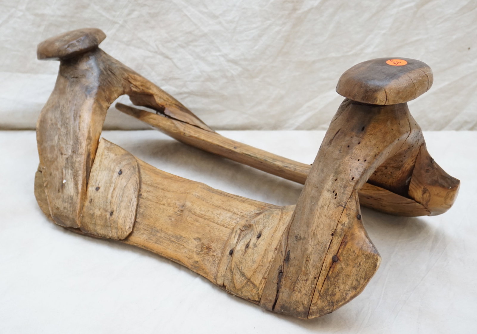 WESTERN-STYLE WOODEN HORSE SADDLE: The western-style wooden saddle is a rustic reminder of the days when horseback was the primary mode of transportation. Its primitive construction and worn surface suggest many journeys across open la