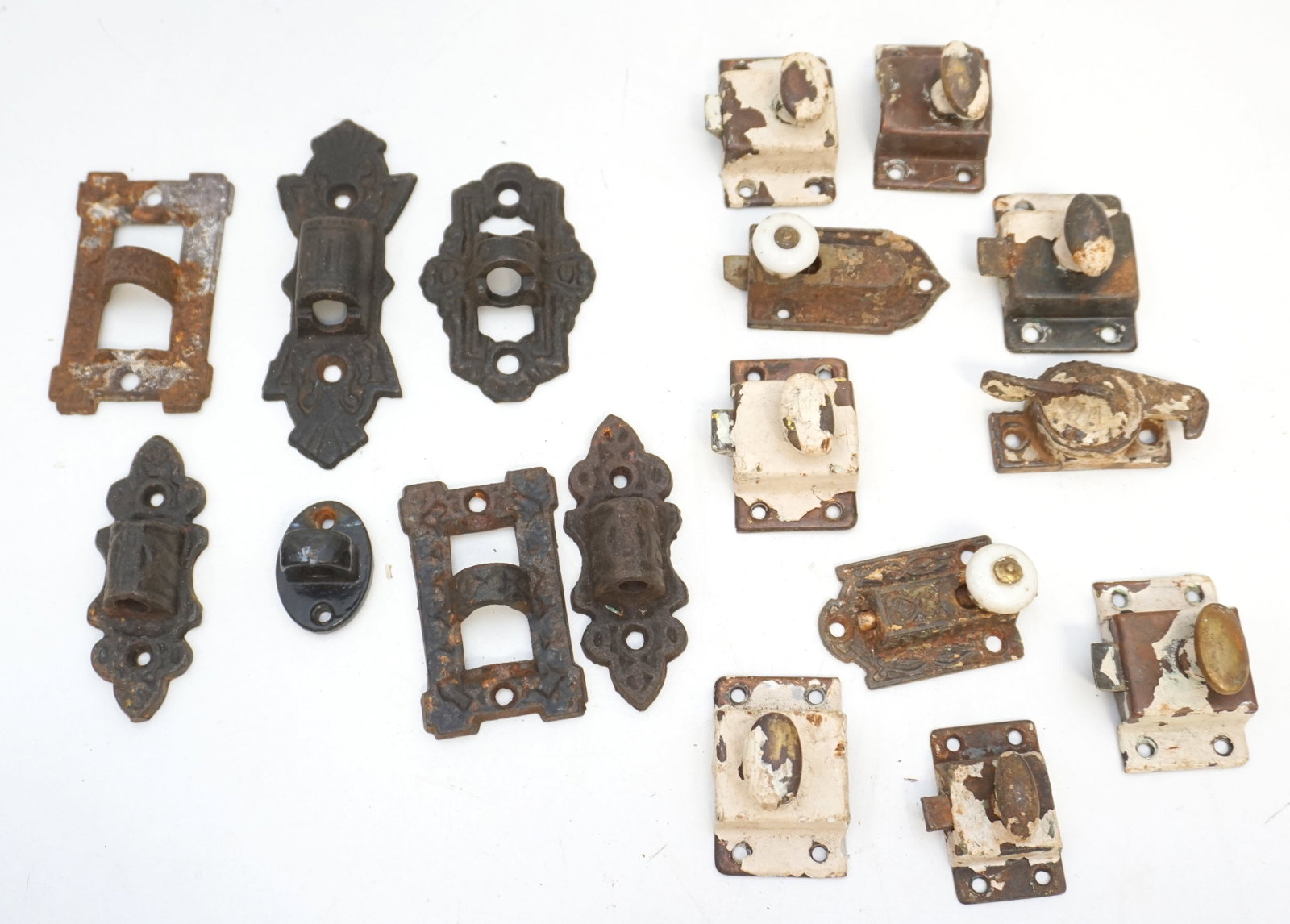 14 VINTAGE & ANTIQUE LATCHES & LAMP HINGES: A selection of vintage and antique cast iron latches and lamp hinges. This group features decorative latches that are for ornamental use, alongside hinges with intricate patterns and shapes, some with