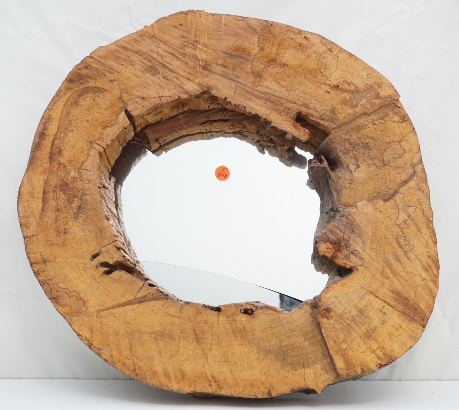 OVAL NATURAL HARD WOOD FRAME: An oval mirror set within a hardwood stump, creating a naturally rustic frame, with dimensions of 21" by 18.5" and a thickness of 3". The mirror glass is cracked, adding to its antique character.