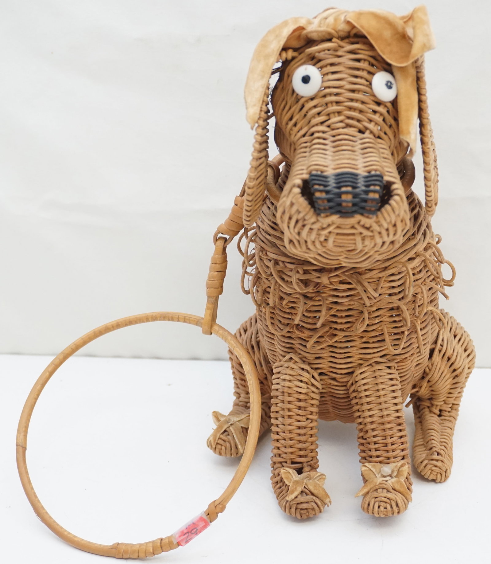 VINTAGE WICKER DOGGIE PURSE/FIGURE: Vintage Wicker Doggie Purse/Figure, standing at 11" high. This charming accessory doubles as a decorative piece, showcasing the versatility and whimsical nature of wicker craftsmanship.