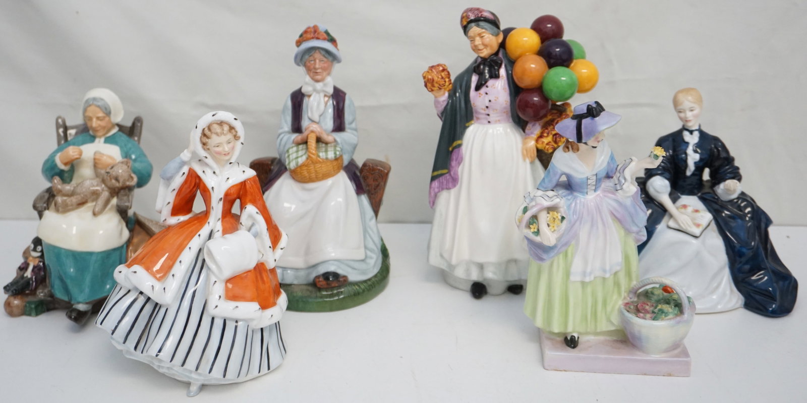 6PC ROYAL DOULTON FEMALE FIGURINES: A charming collection of six Royal Doulton female figurines, each capturing the essence of Victorian femininity in various poses and attire. The set includes notable pieces such as "Noelle," "Rest Awh