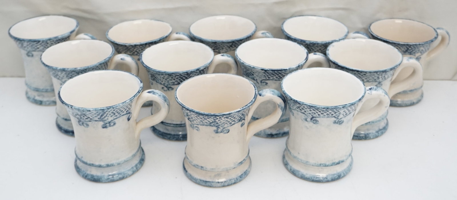 "BURANO" BY ARTE ITALICA 12 COFFEE CUPS: A set of twelve coffee cups from the "Burano" collection by Arte Italica, each standing 4" high and weighing a total of 11lbs. These cups continue the tradition of handcrafted excellence with detailed