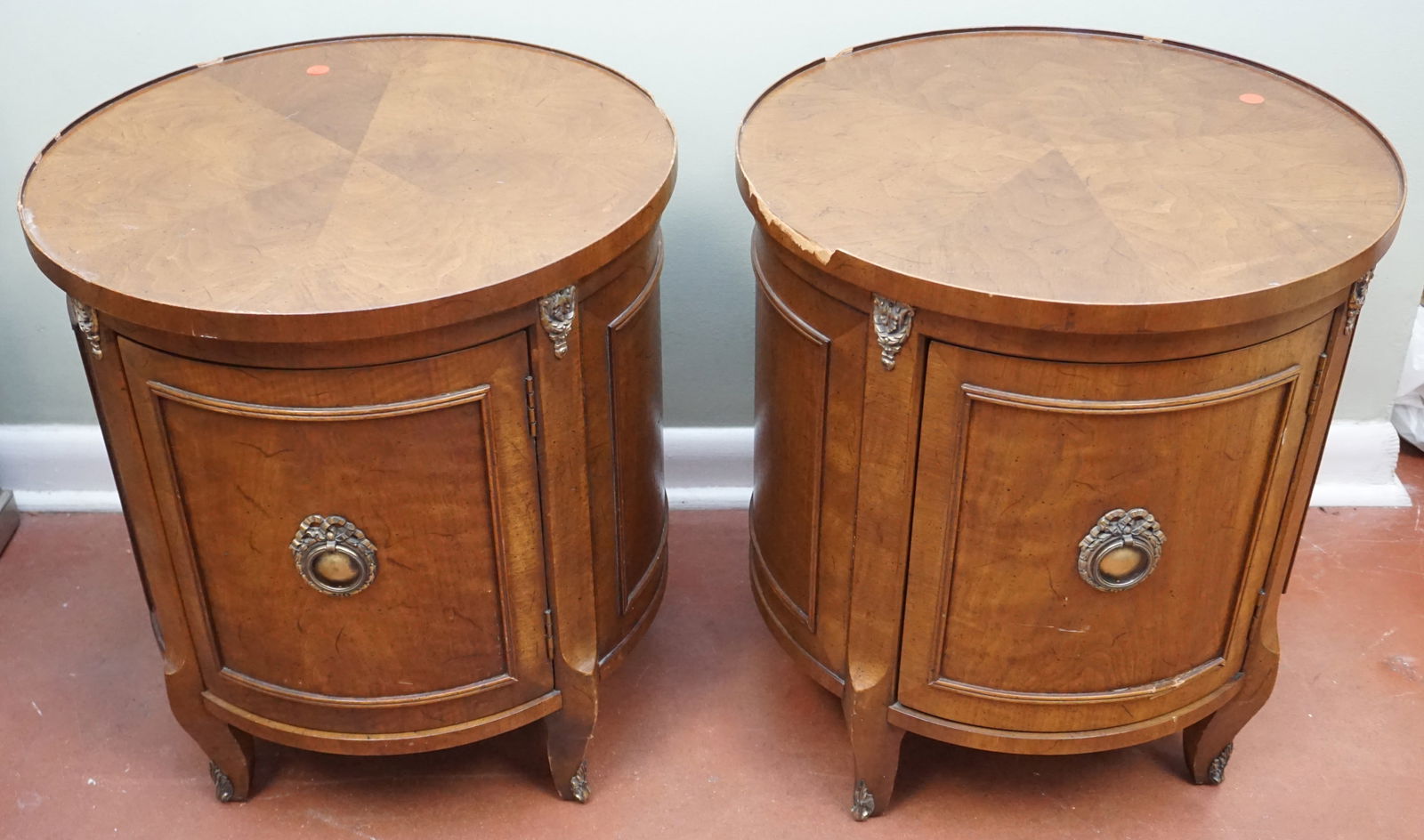 MATCHING DRUM TABLES: These are two matching round-topped drum tables, beautifully crafted with a burled wood finish, which gives them a rich and intricate appearance. The design features curved doors accented with decorat