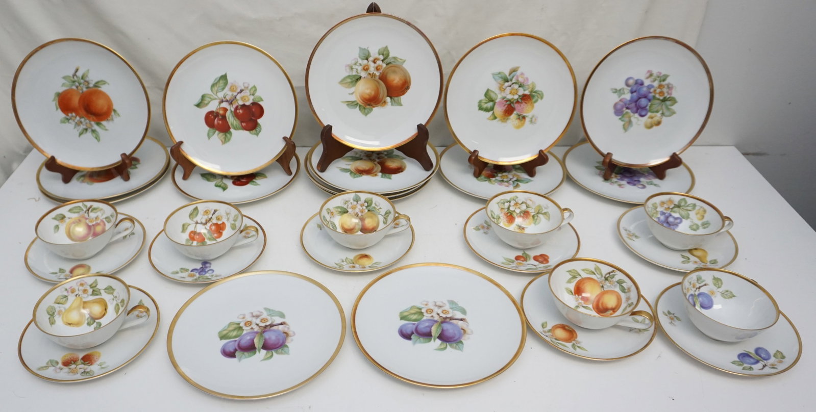 32PC BONE CHINA: Collection of 32 pieces of Hutschenreuther Gelb china, consisting of 16 salad plates, 8 cups, and 8 saucers. The salad plates measure 8" in diameter and feature various fruit motifs, including three w
