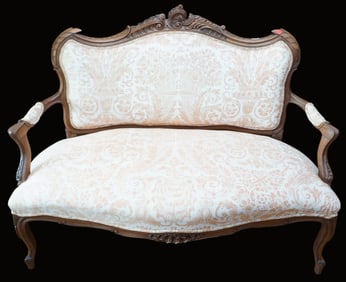 ANTIQUE CARVED SETTEE WITH PEACH AND WHITE UPHOLSTERY