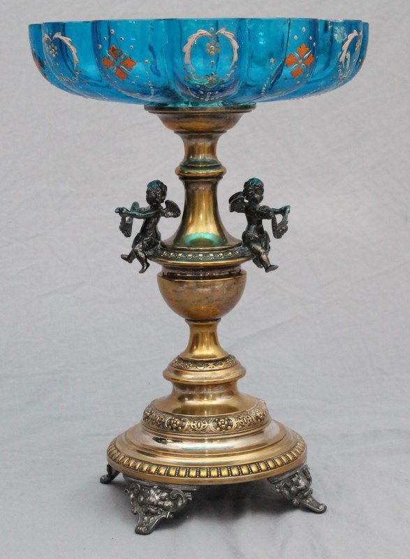 LARGE WMF GILDED CHERUB COMPOTE ENAMELED COBALT GLASS: Large Antique WMF Gilded metal and Bohemian Cobalt Enameled Glass Compote. Measures 11"x11"x15 1/2"tall and has a very old repair. The glass was broken in half, was glued and then stapled using iron s