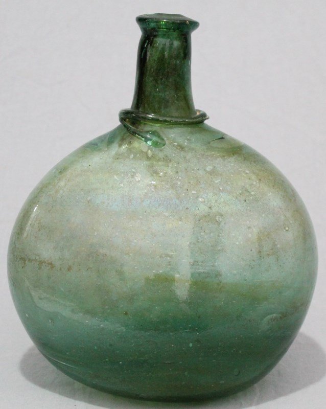 ANCIENT LARGE ROMAN GREEN GLASS FLASK: Large Green Ancient Roman Blown Glass Flask Bottle. Attributed to the Roman Empire, Ca 2nd to fourth century CE. Stunning green color with beautiful iridescence throughout. Has linear wrap design on n