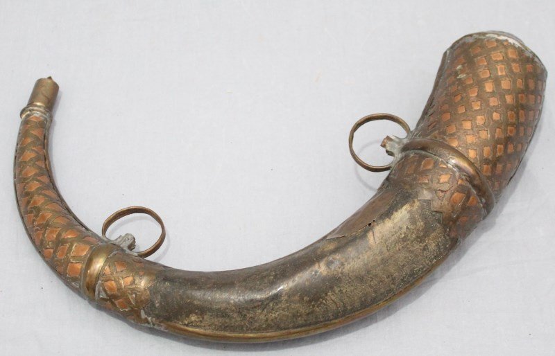 LARGE 19TH CENTURY BRASS MOUNTED PERSIAN POWDER HORN: Very large nineteenth-century copper and brass mounted Persian powder horn. Measures 29" long. Signed in arabic. Of typical form with horn body. The mounts of copper, heavily overlaid in brass pierced