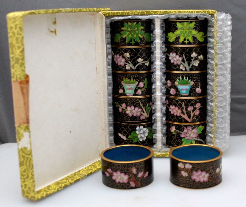SET OF 12 CHINESE CLOISONNE NAPKIN RINGS: A group Consisting of twelve floral decorated napkin rings on black ground with turquoise interiors, circa 20th century, 1.15" H x 2.15" Diameter, very good condition. 10 in the Original Box. Provenan
