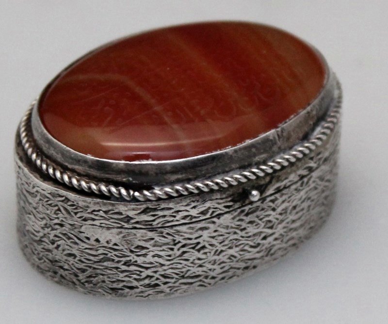 CARNELIAN & STERLING PERSIAN ARABIC SNUFF / PILL BOX: Vintage Sterling Silver and Carnelian Snuff / Pill Box. The top is Arabic calligraphy inscribed, possibly a prayer, polished oval carnelian set in a rope twist bezel, the sides are ornate and the bott
