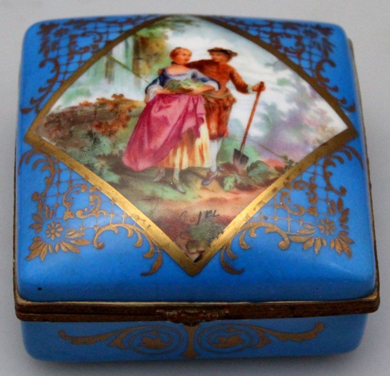 SIGNED FRENCH HP DRESSER BOX SEVRES STYLE: Signed French Sevres style porcelain hand painted dresser box. Sevres blue ground with hand painted gilt accents and a romantic gardening center medallion which is signed. Bronze fittings.The bottom h