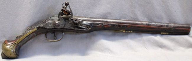 MIDDLE EASTERN ARABIC FLINTLOCK PISTOL: Antique 19th c. Persian Flintlock Pistol signed in Arabic. Engraved motif locks, barrel chiseled and inlaid with brass and silver, the stock and ball butt decorated with brass, and inlaid onyx and bon