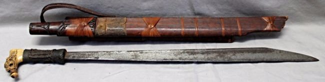 19th C. SEA DAYAK HEADHUNTERS SWORD: 19th century Sea Dayak Head Hunters Mandau Sword. From the Dayak people, Borneo.The handle is made of bone that features some very fine engravings and remnants of animal hair. The handle is completely