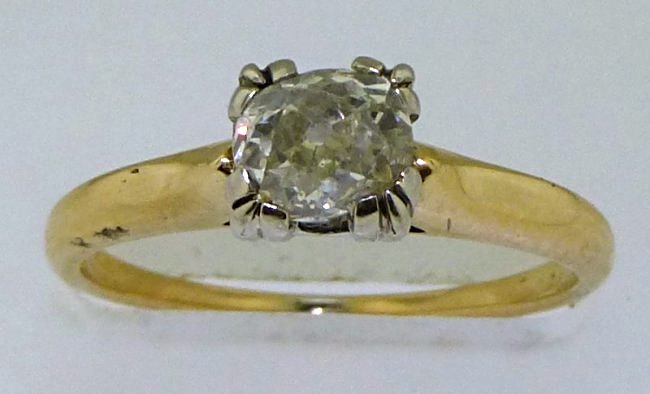 14K DIAMOND SOLITAIRE ESTATE RING: This beautiful 14kt two tone gold diamond ring is a classic solitaire with a flair of the past. The ring is a size "5.25" and features one (1), four prong set, ovalish hand cut diamond set in the cent