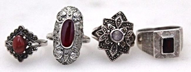 4 ESTATE STERLING AND MARCASITE RINGS: Group of 4 Vintage Estate Sterling and Marcasite Rings. All marked 925. A 1940-50s square garnet stone set in a textured sterling ring, a stunning oval carnelian look stone with marcasites, a cabochon