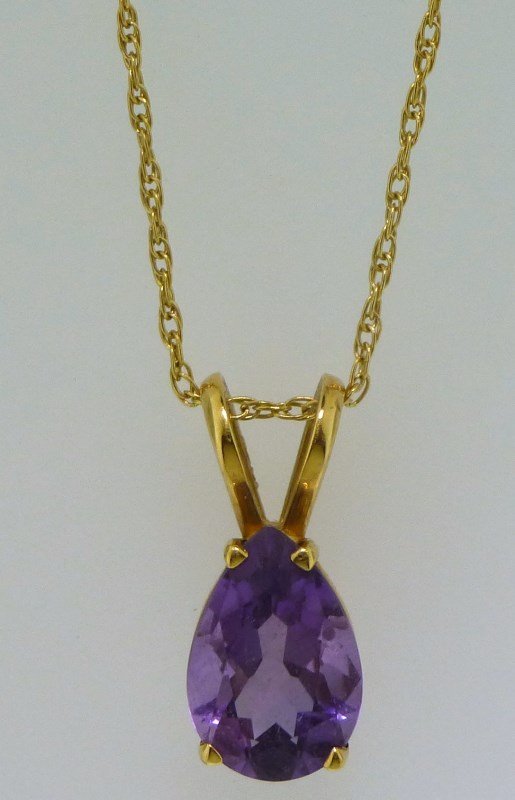 AMETHYST 14KT GOLD NECKLACE: This lot is a delicate solitaire style amethyst drop necklace. The chain is approx. 19.00" in length, approx. 0.77mm thick and has a spring ring clasp. The pendant features one (1), four prong set, pe